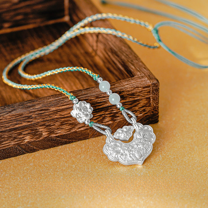 Silver Pisces Koi Necklace with intricate peace lock and lotus motifs, paired with jade beads and braided cord. Elegant handcrafted design.